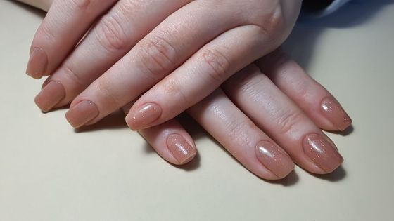 A close up of a woman's hands with long nails on a table