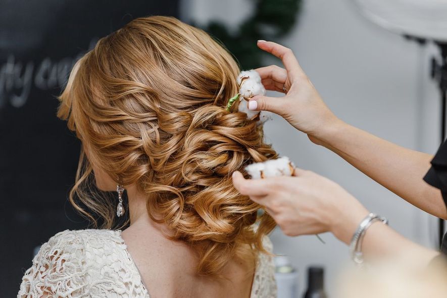 A woman is getting her hair done by a hairdresser in a salon