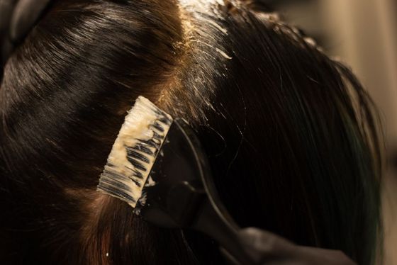 A woman is getting her hair dyed in a salon