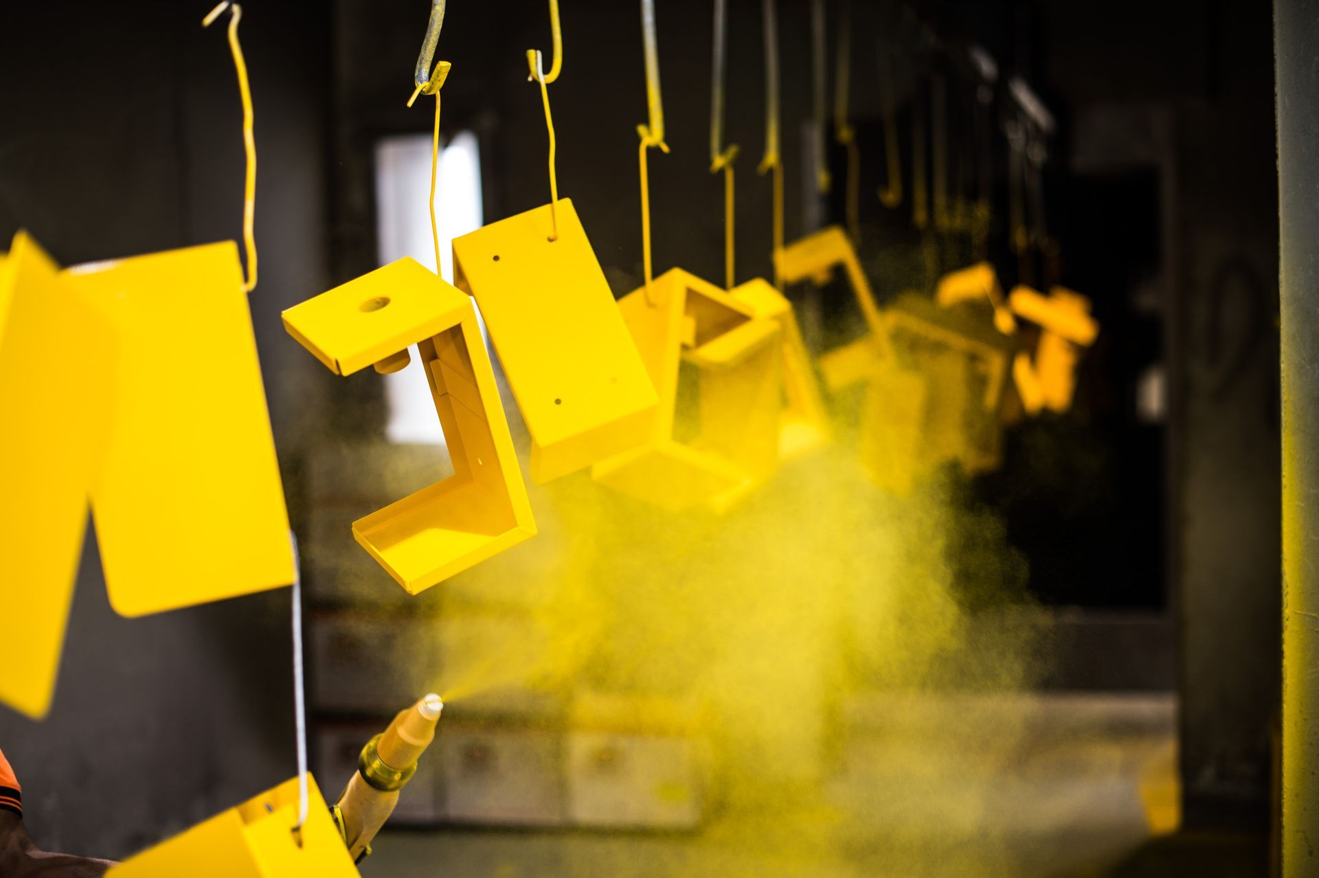 The painting of various metal objects with a power coating spray.