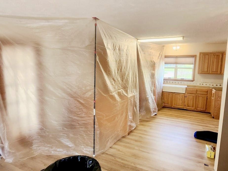A kitchen with a plastic sheet covering the walls.