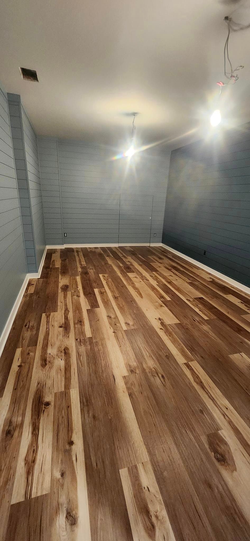 A room with a wooden floor and blue walls.