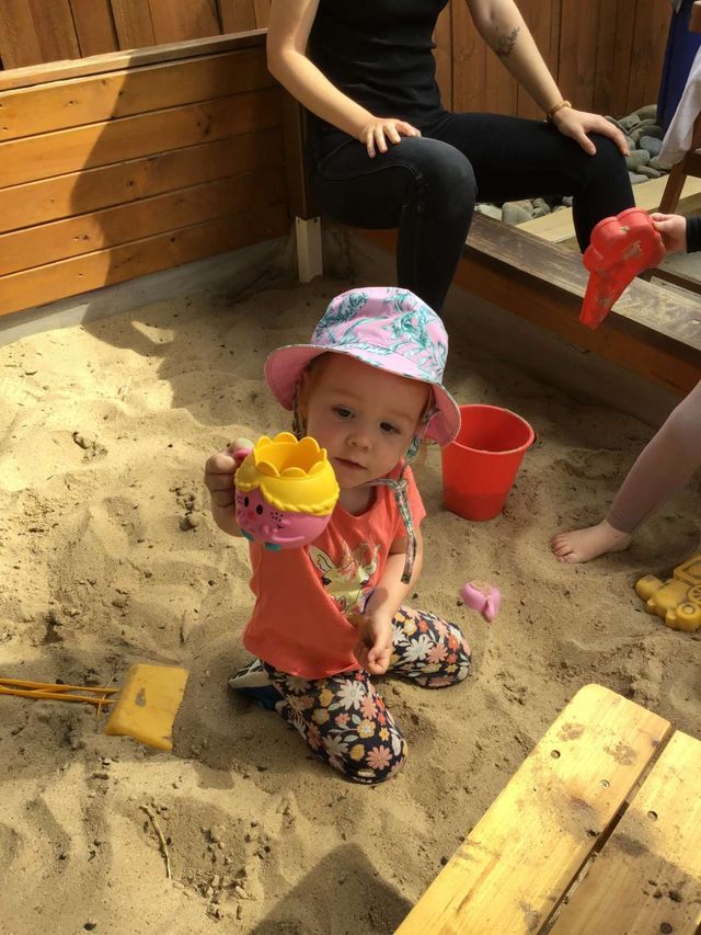A Little Girl in a Pink Hat is Playing in the Sand — Preschool in Coffs Harbour