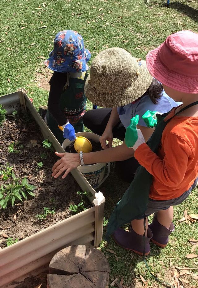 Children and Women Engaged in Planting a Tree at Lilly Pilly Early Learning Centre — Preschool in Coffs Harbour