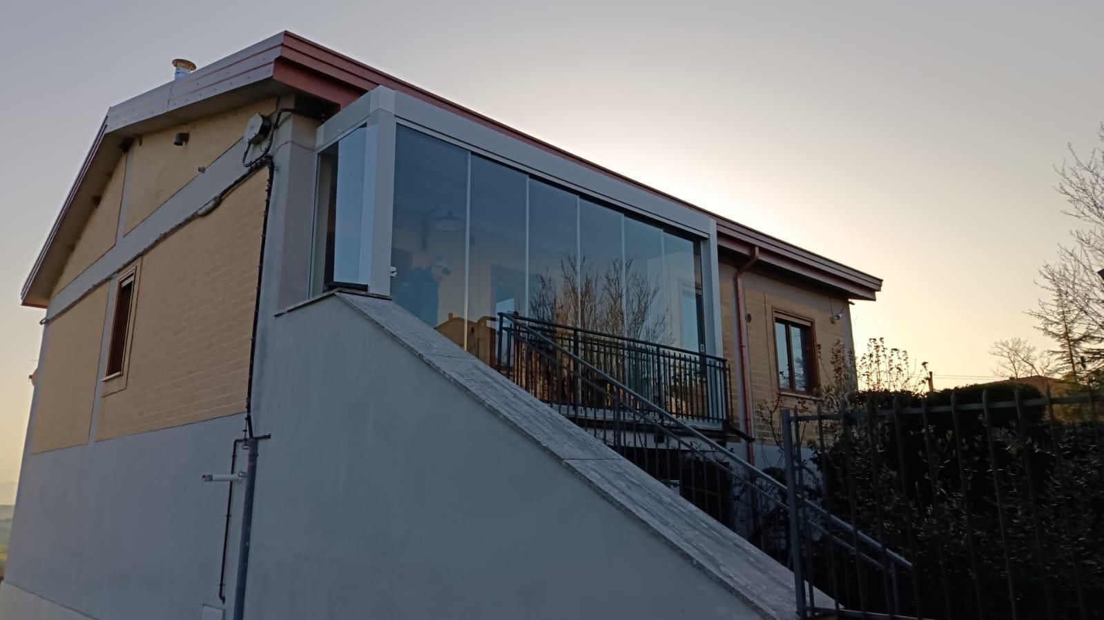 Una casa con un balcone e delle scale per accedervi.