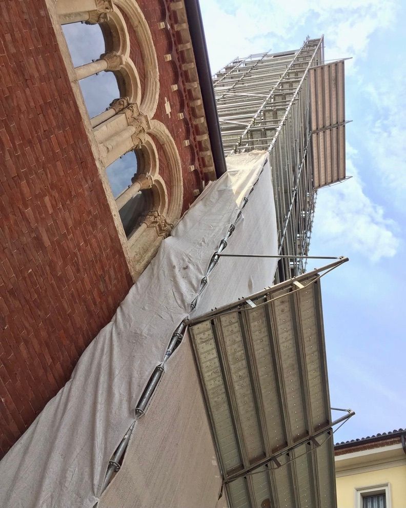 un edificio di mattoni con un'impalcatura sul lato