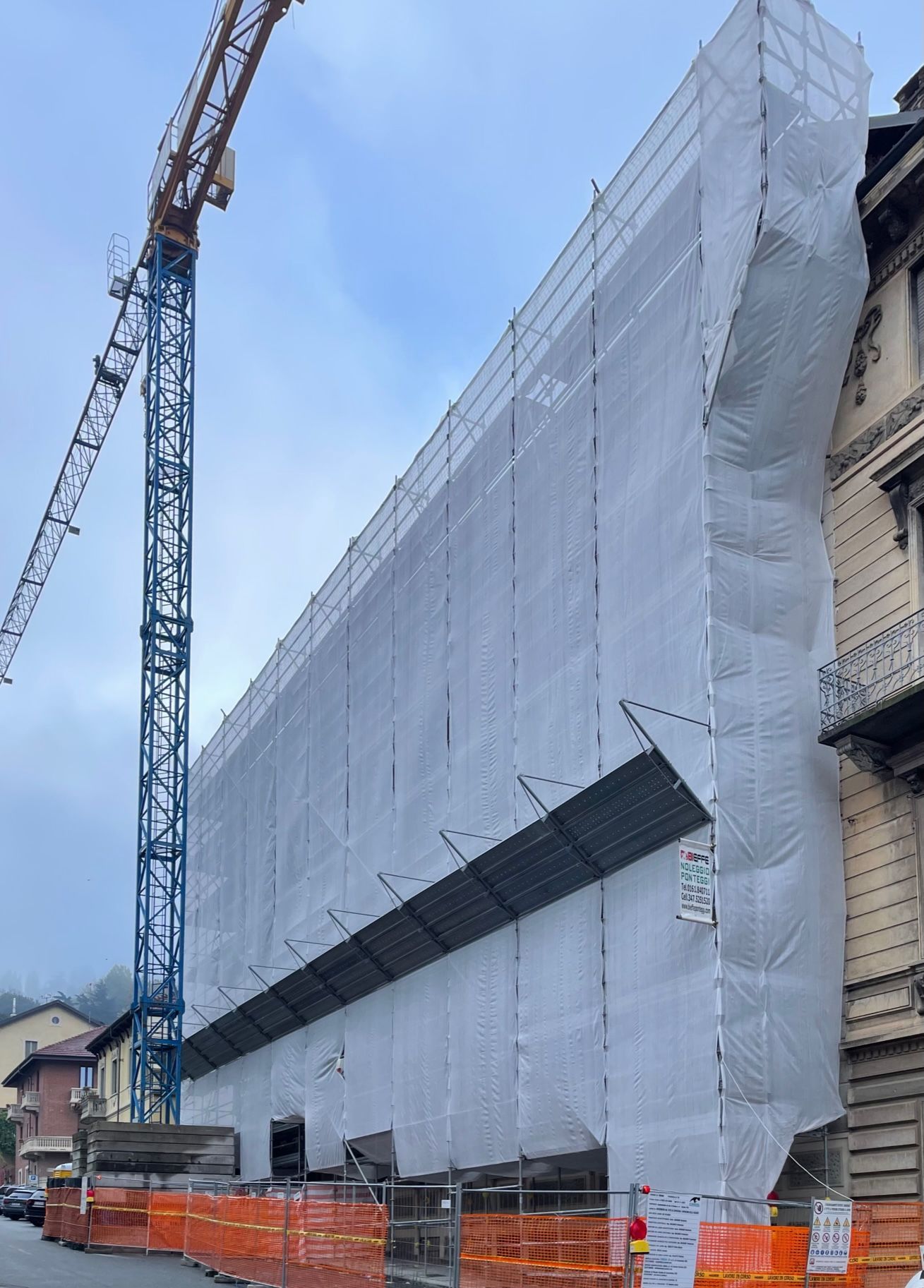 un grande edificio in costruzione con una gru sullo sfondo