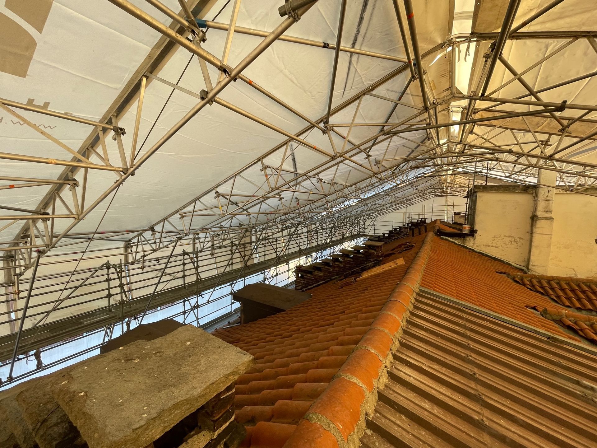 il tetto di un edificio è coperto da un'impalcatura e da un telone.