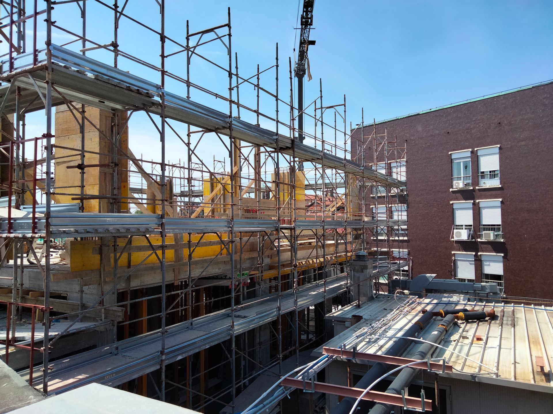 un cantiere con impalcature e una gru sullo sfondo