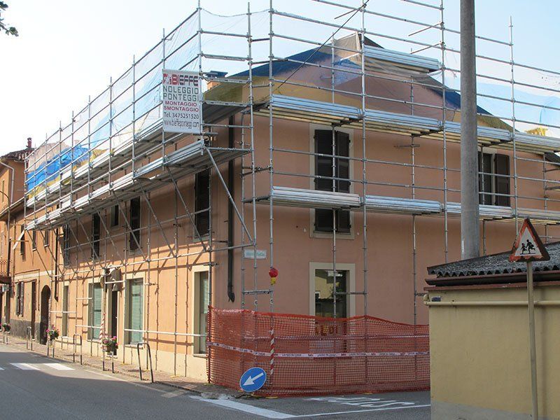 un edificio in costruzione con impalcature sul lato