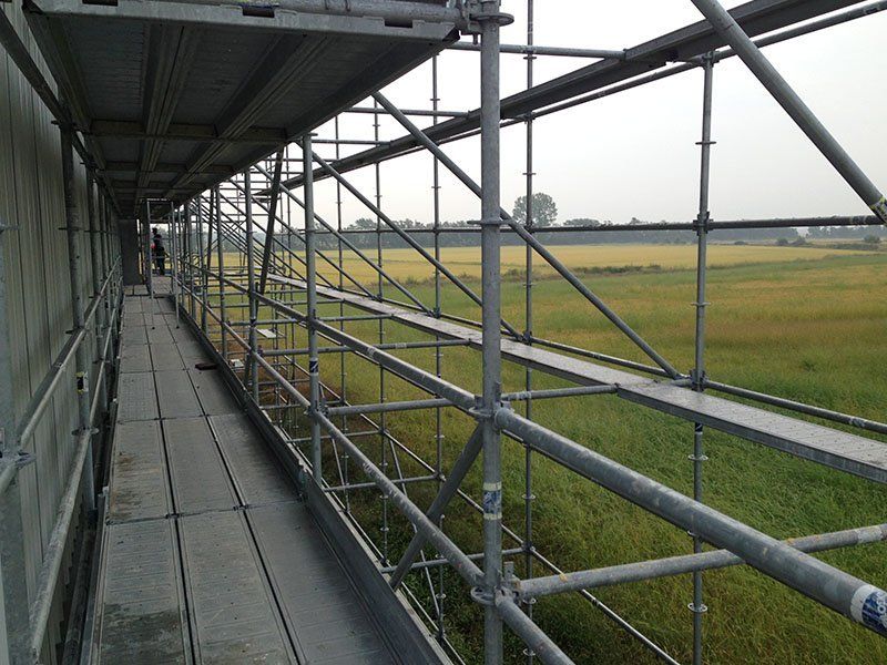 una fila di impalcature con un campo sullo sfondo