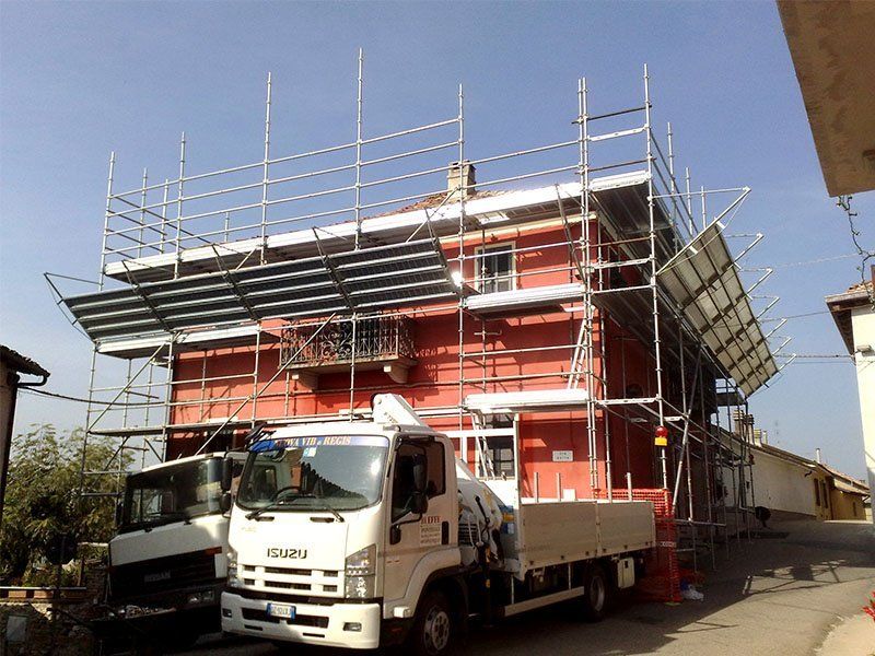 un camion isuzu bianco è parcheggiato davanti a un edificio in costruzione