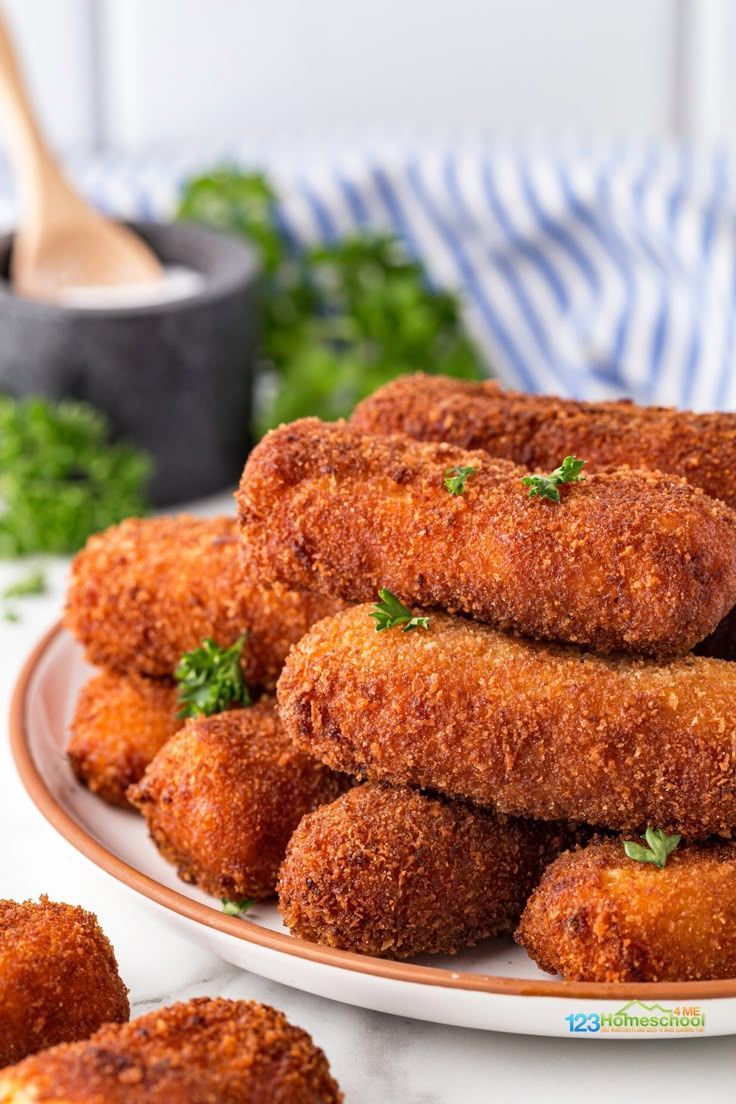 Plate of golden-brown, breaded, and fried food, possibly croquettes or similar, with parsley garnish.