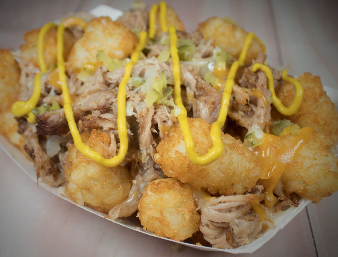 Pulled pork tater tot dish topped with mustard.