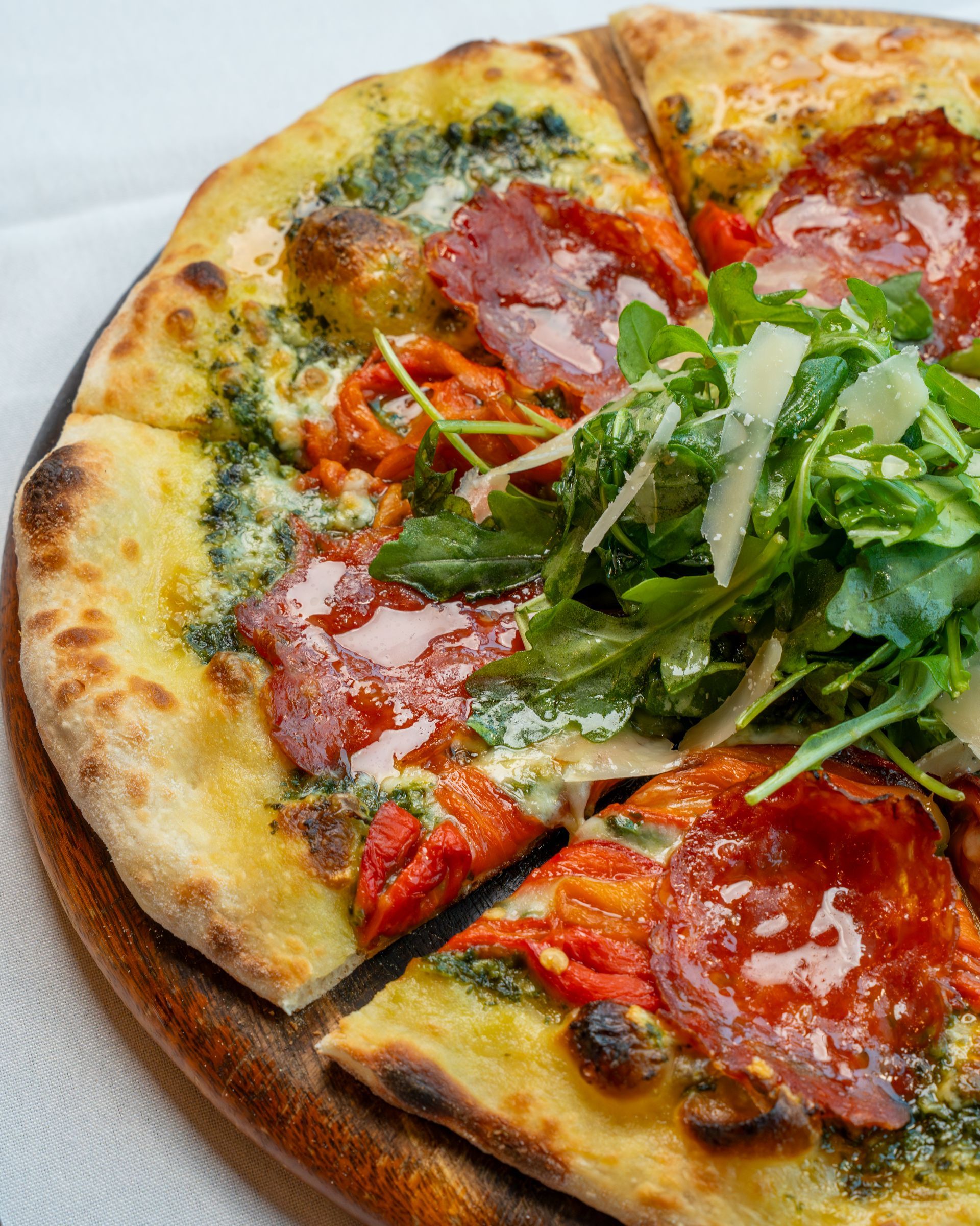 A pizza is sitting on a cutting board on a counter in a kitchen.