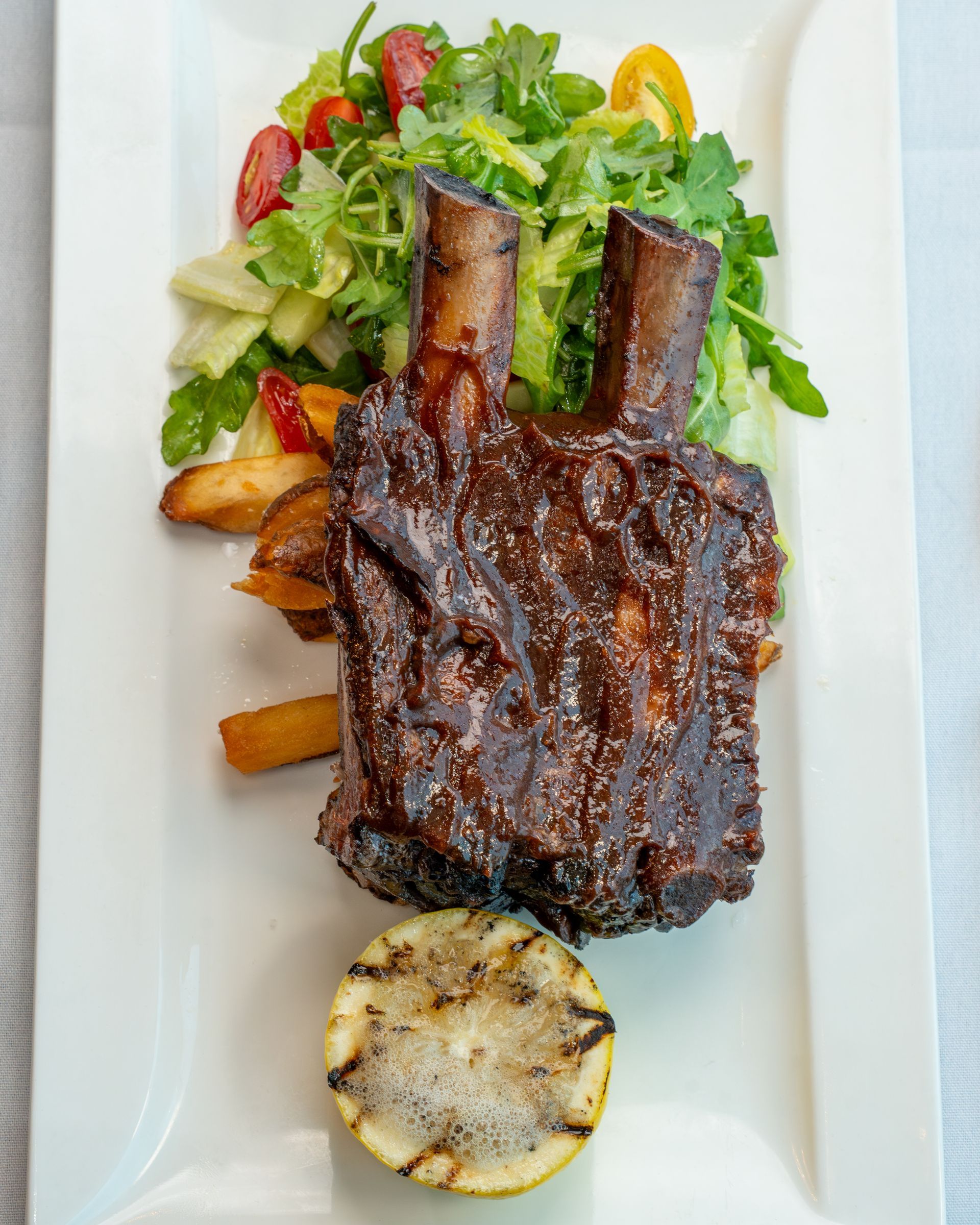 A chef is preparing plates of food in a kitchen.