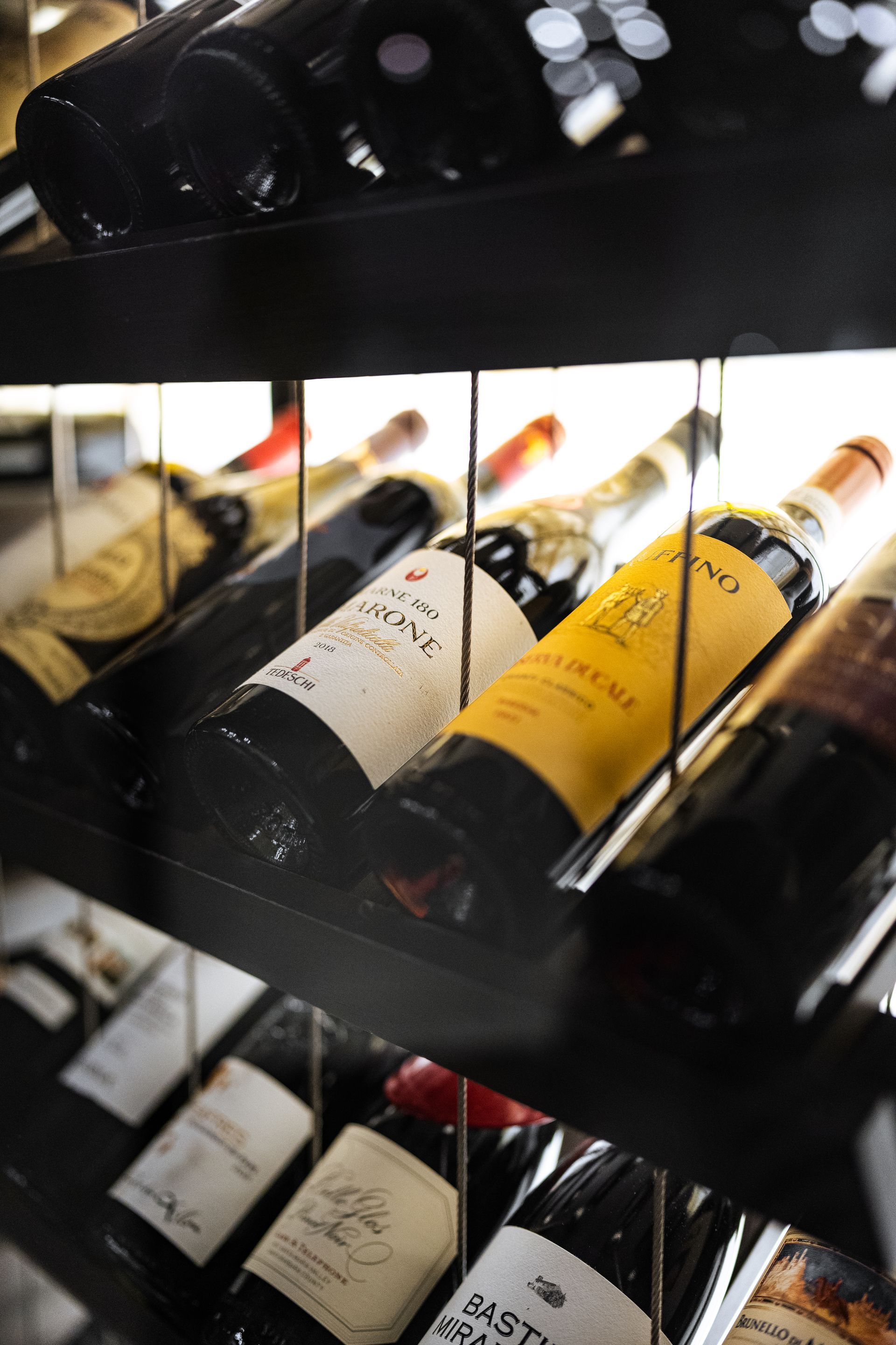 Several bottles of wine are lined up on a shelf