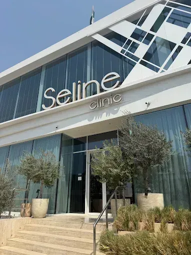 Exterior of Selina Clinic, a modern building with glass windows, white accents, and a sign above the entrance.