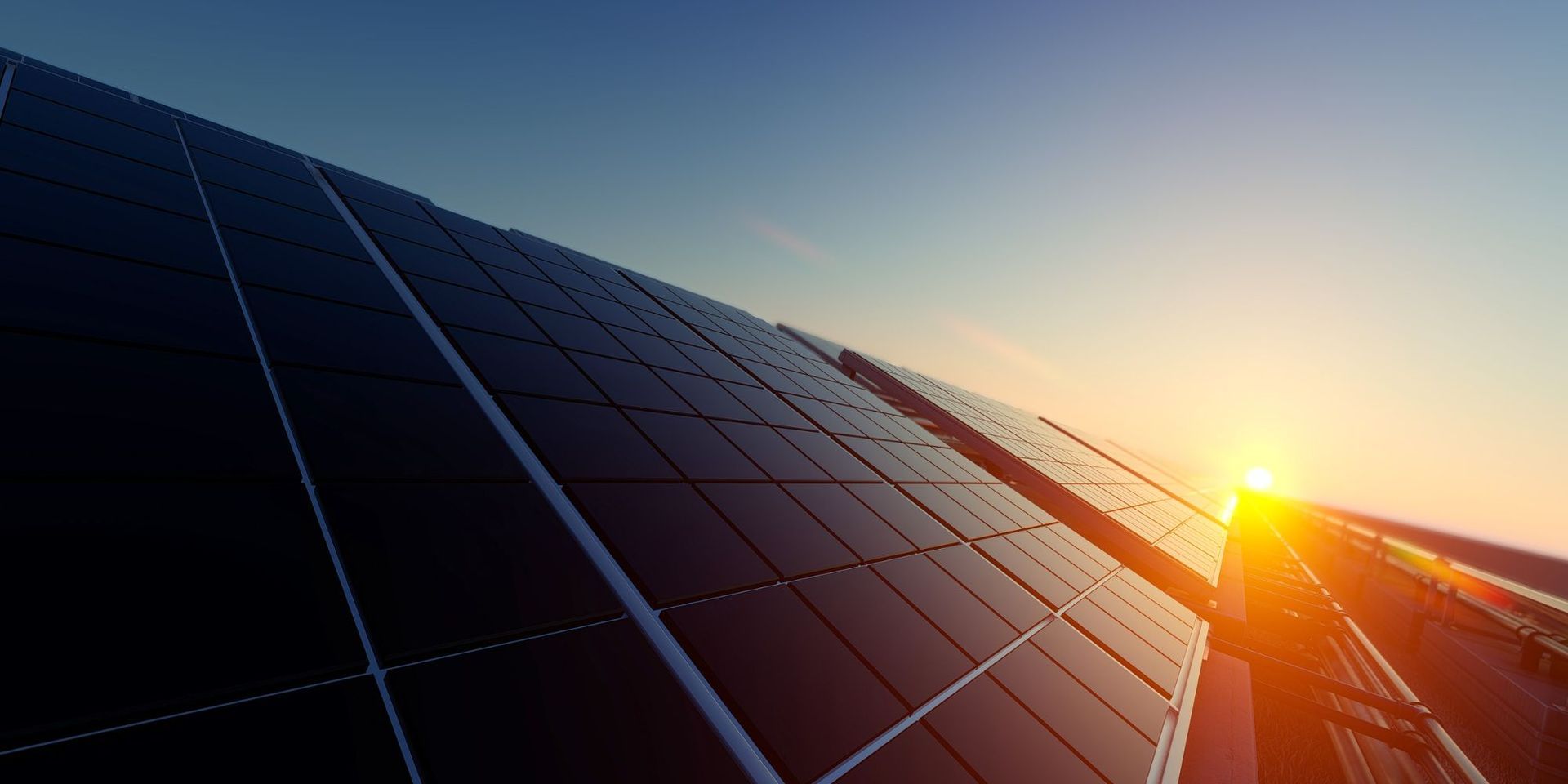 The sun is shining through the solar panels at sunset.