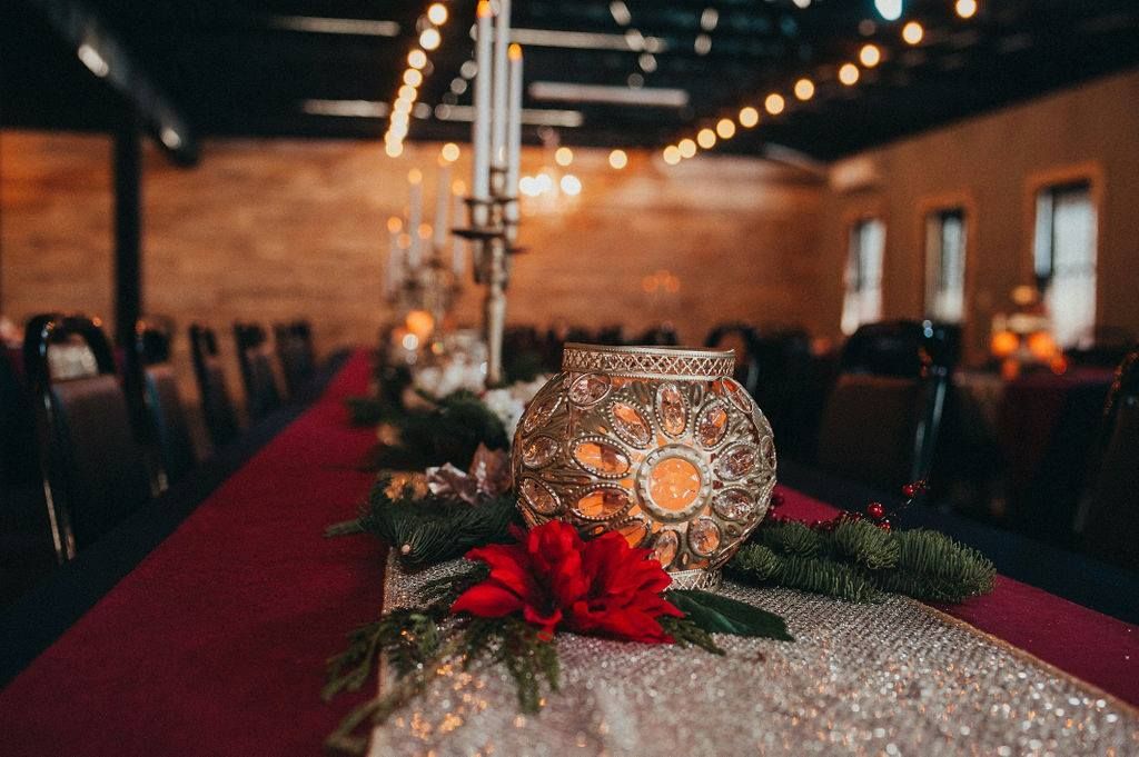 A long table with a vase and candles on it.