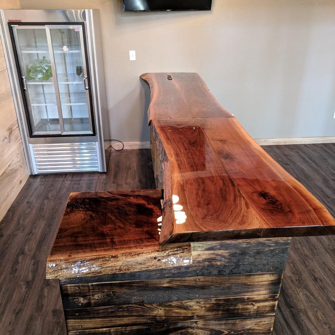A wooden bar with a refrigerator in the background.