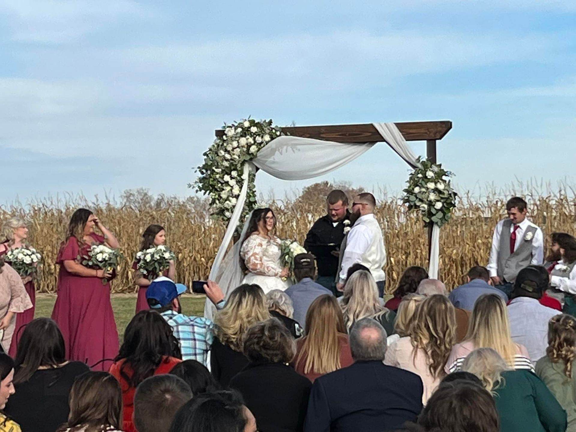 A bride and groom are getting married in front of a crowd of people.