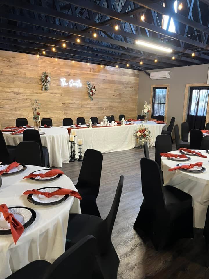 A large room with tables and chairs set up for a wedding reception.