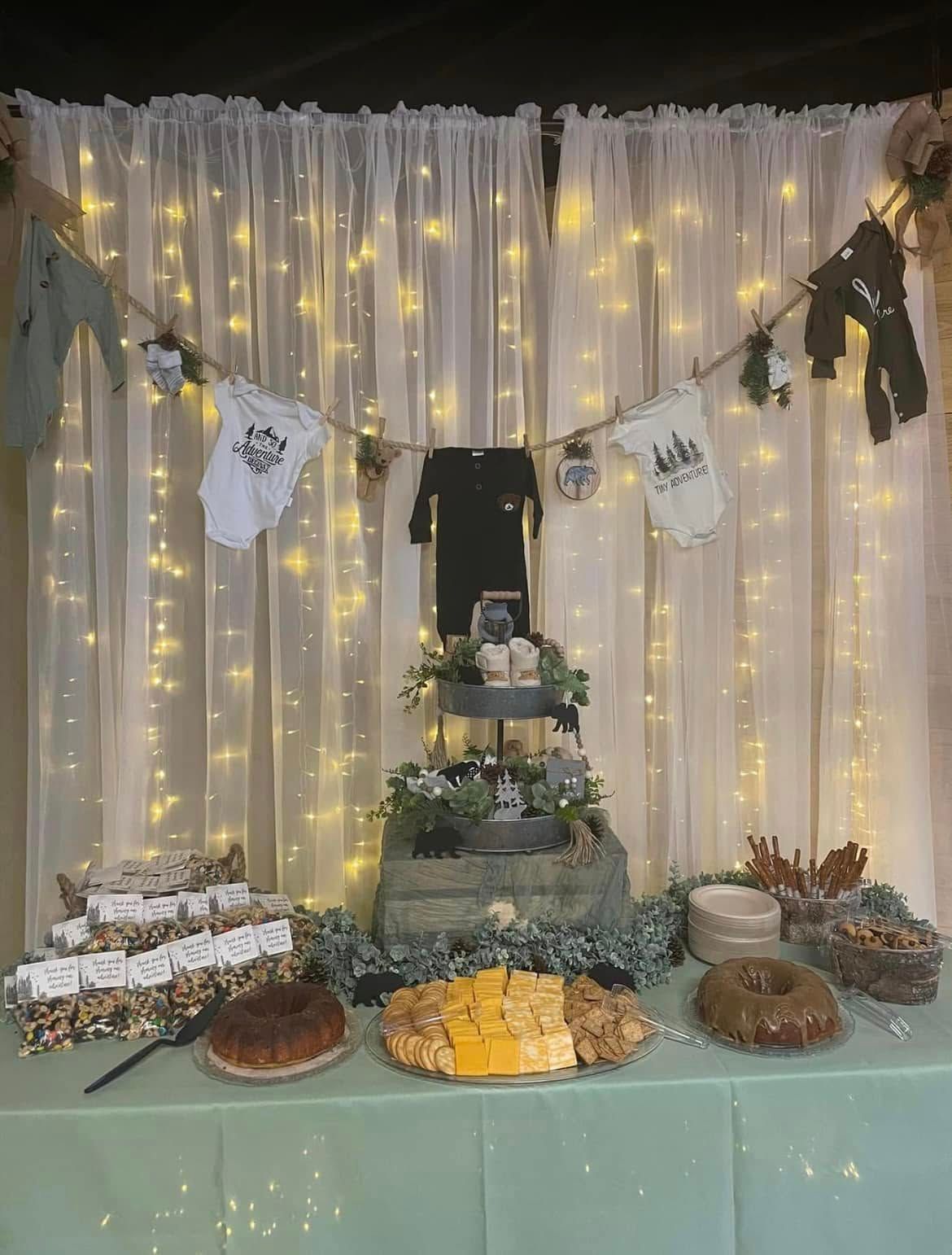 A table with a lot of food on it in front of a white curtain.