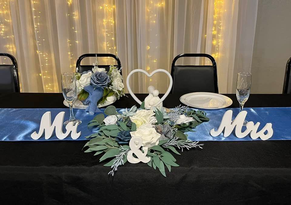 A table with flowers and a sign that says mr. and mrs. on it.