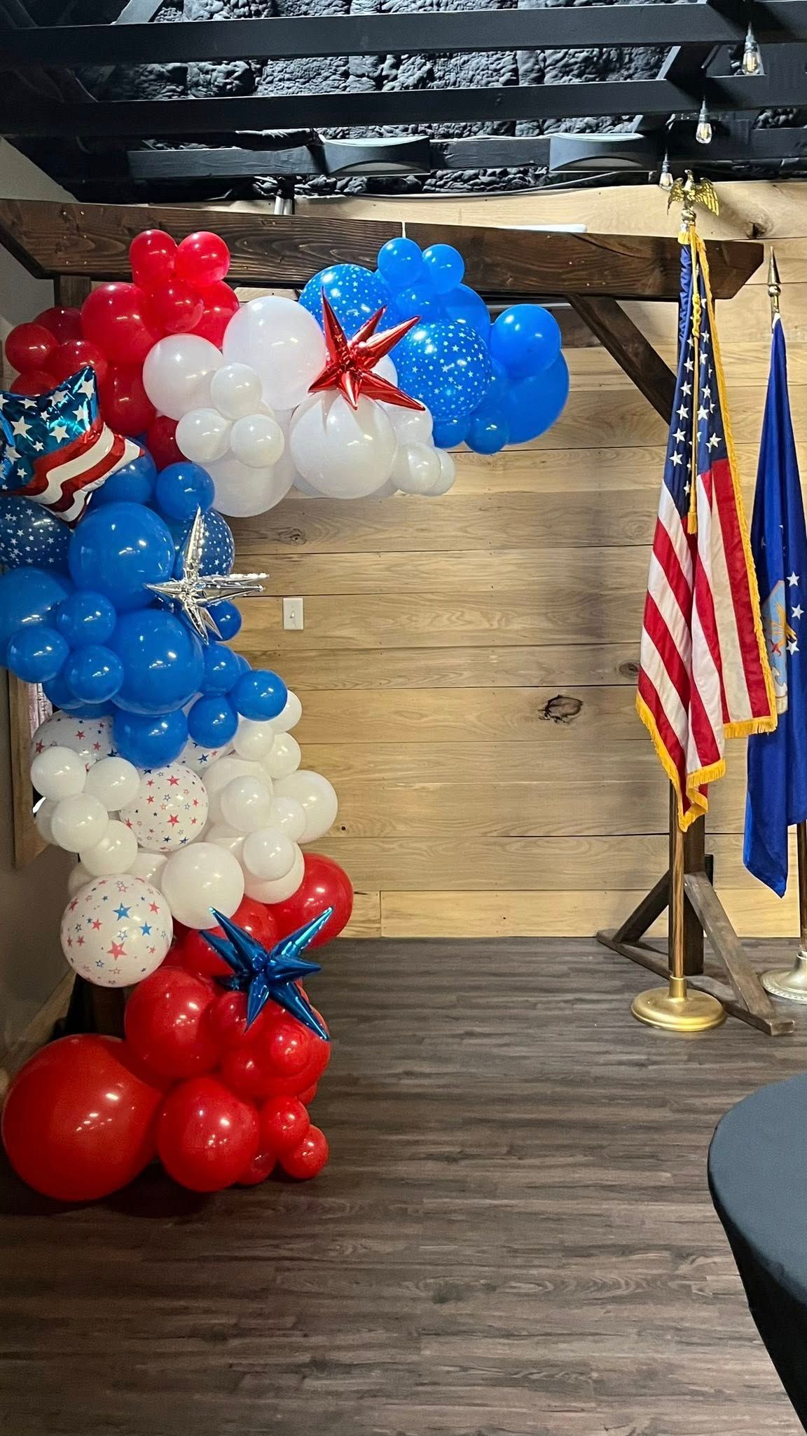 A room filled with red , white and blue balloons and american flags.