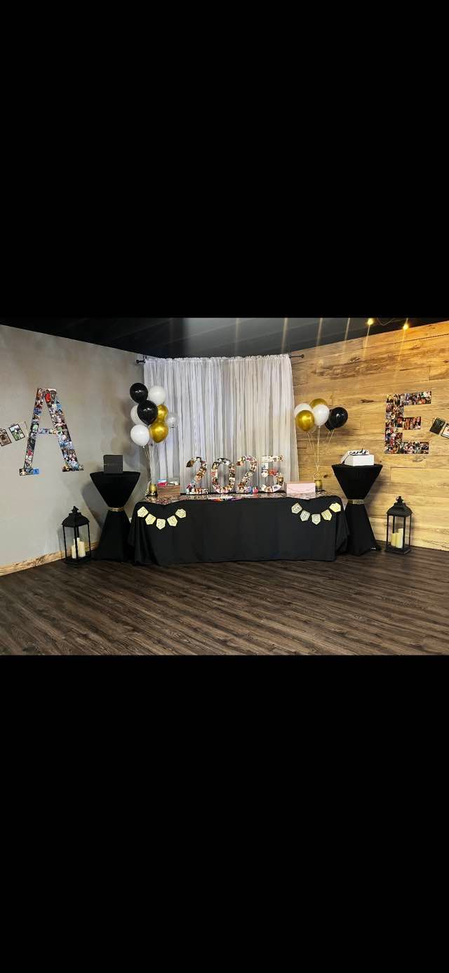 There is a table with balloons on it in the middle of the room.
