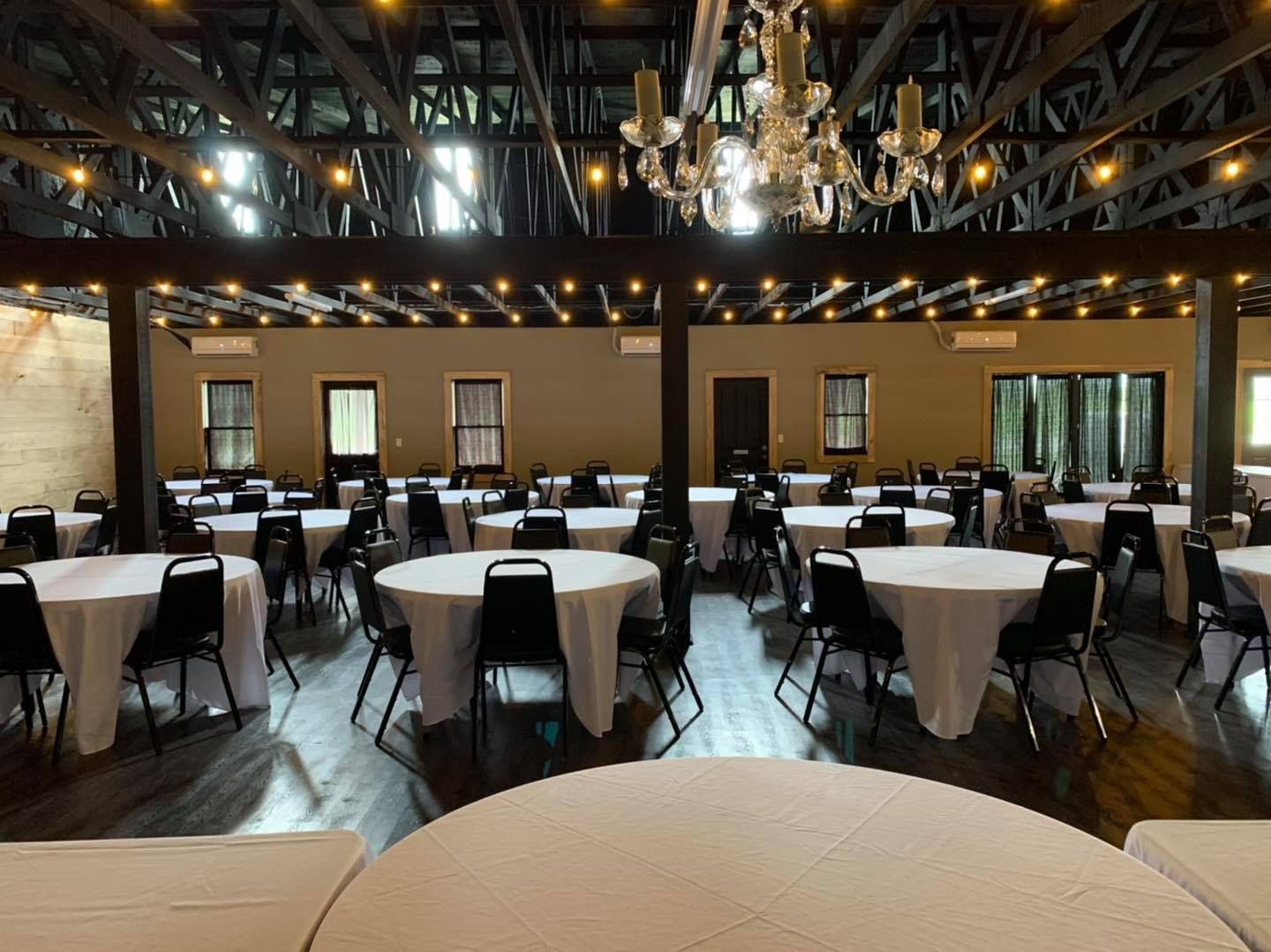 A large room filled with tables and chairs and a chandelier.