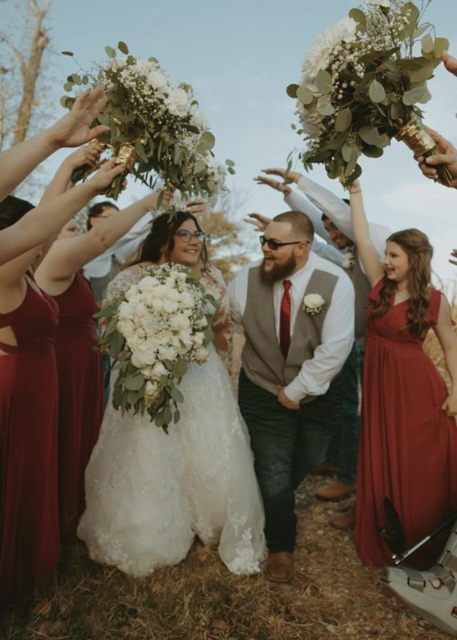 A bride and groom are walking down the aisle with their wedding party.