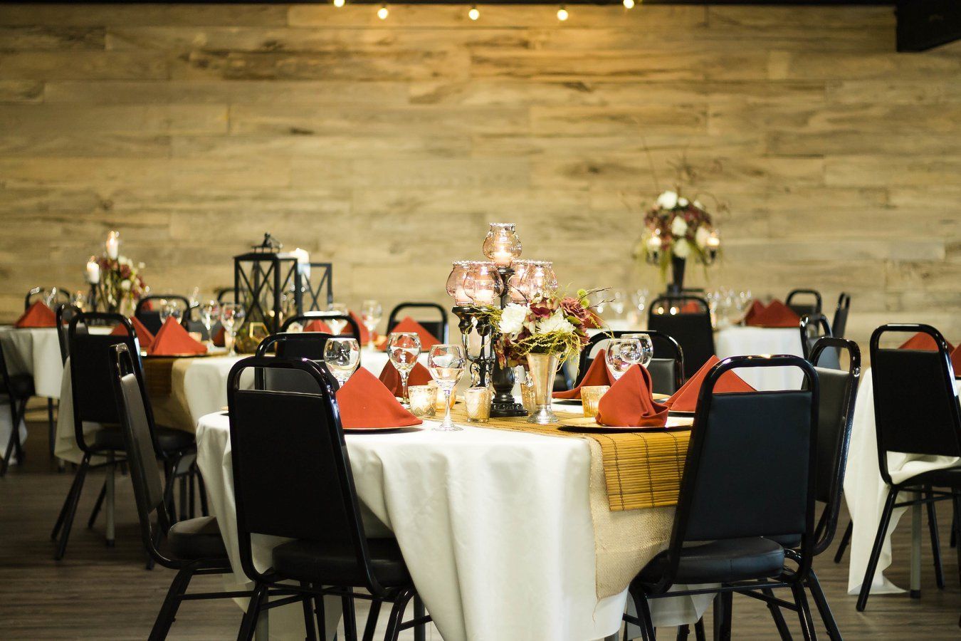 A room filled with tables and chairs set up for a wedding reception.