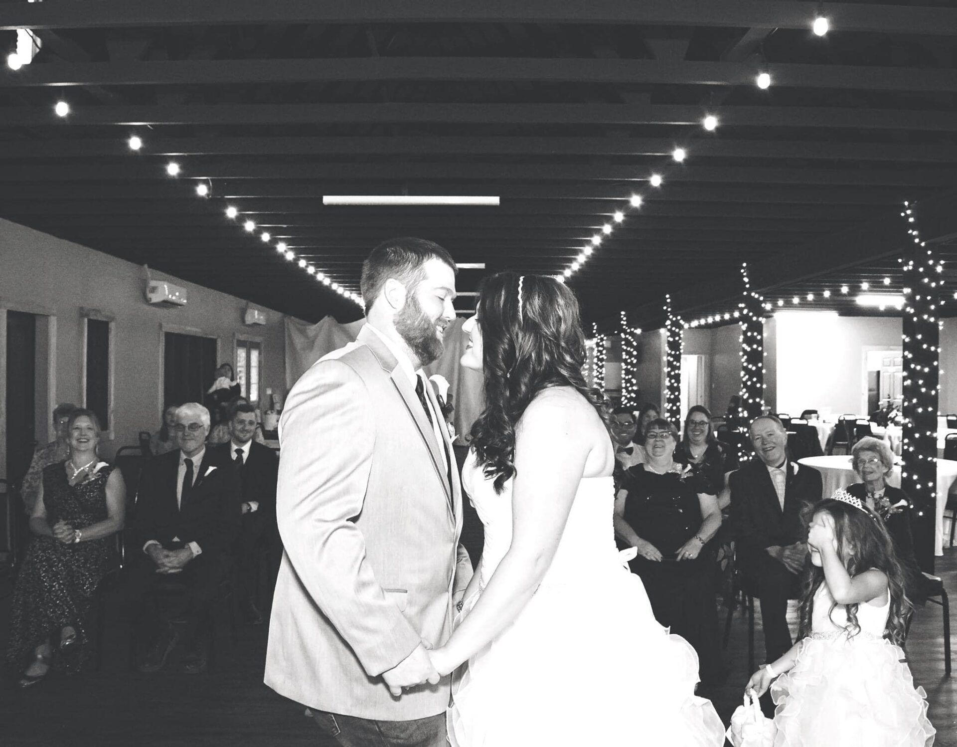 A black and white photo of a bride and groom dancing at their wedding reception.
