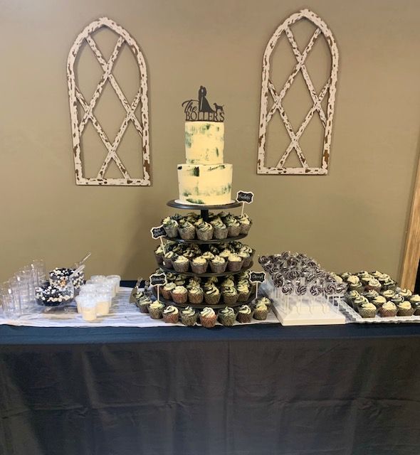 A table with a cake and cupcakes on it