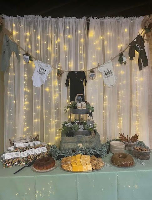 A table with a lot of food on it in front of a white curtain.