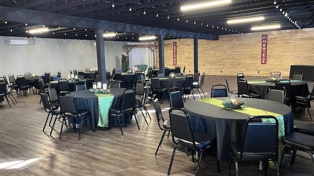 A large room with tables and chairs set up for a party.