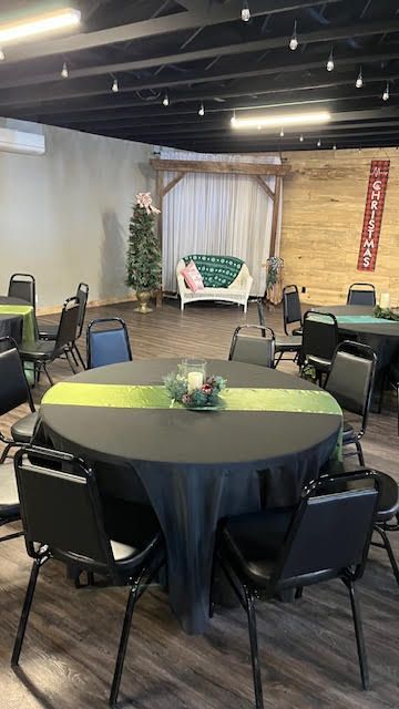 A large room with tables and chairs set up for a party.