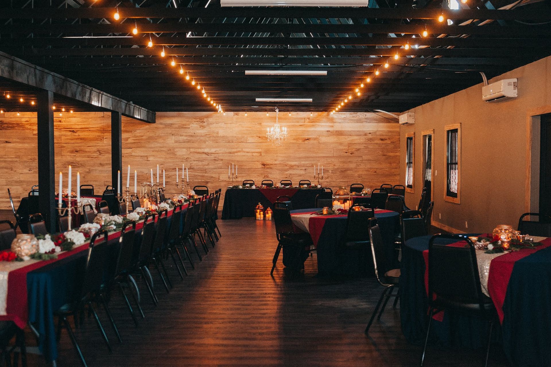 A large room with tables and chairs set up for a wedding reception.