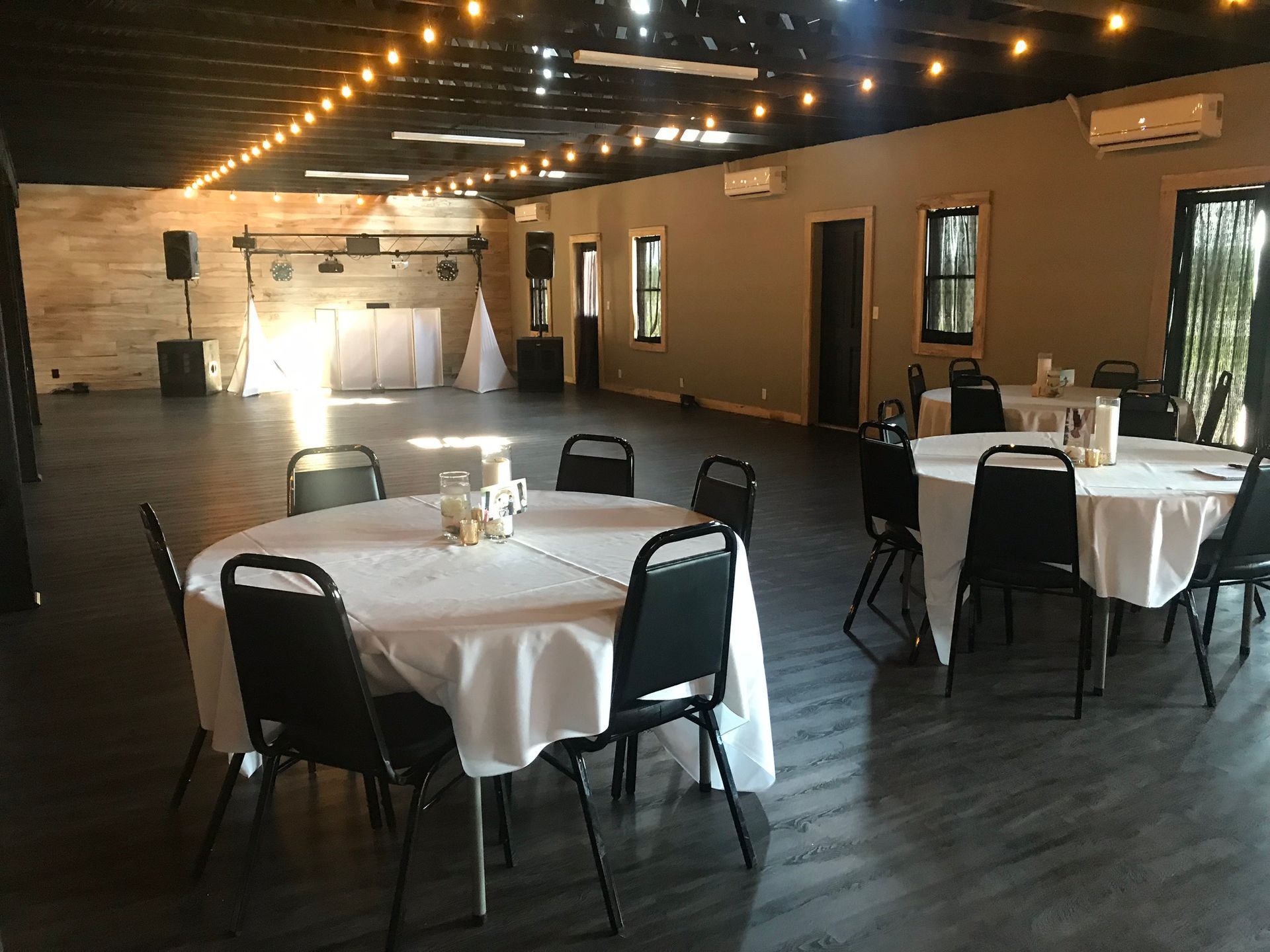 A large room with tables and chairs set up for a wedding reception.