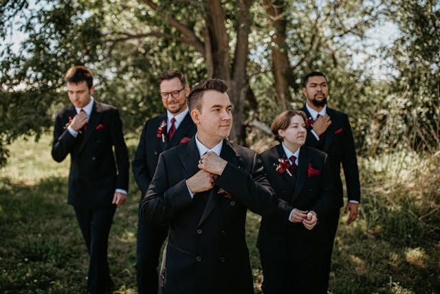 A group of men in suits and ties are walking in a field.