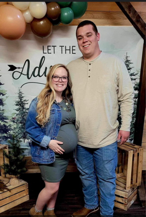 A man and a pregnant woman are posing for a picture.