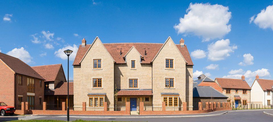 A large building of honey coloured brick with cobalt blue front door and timber window frames