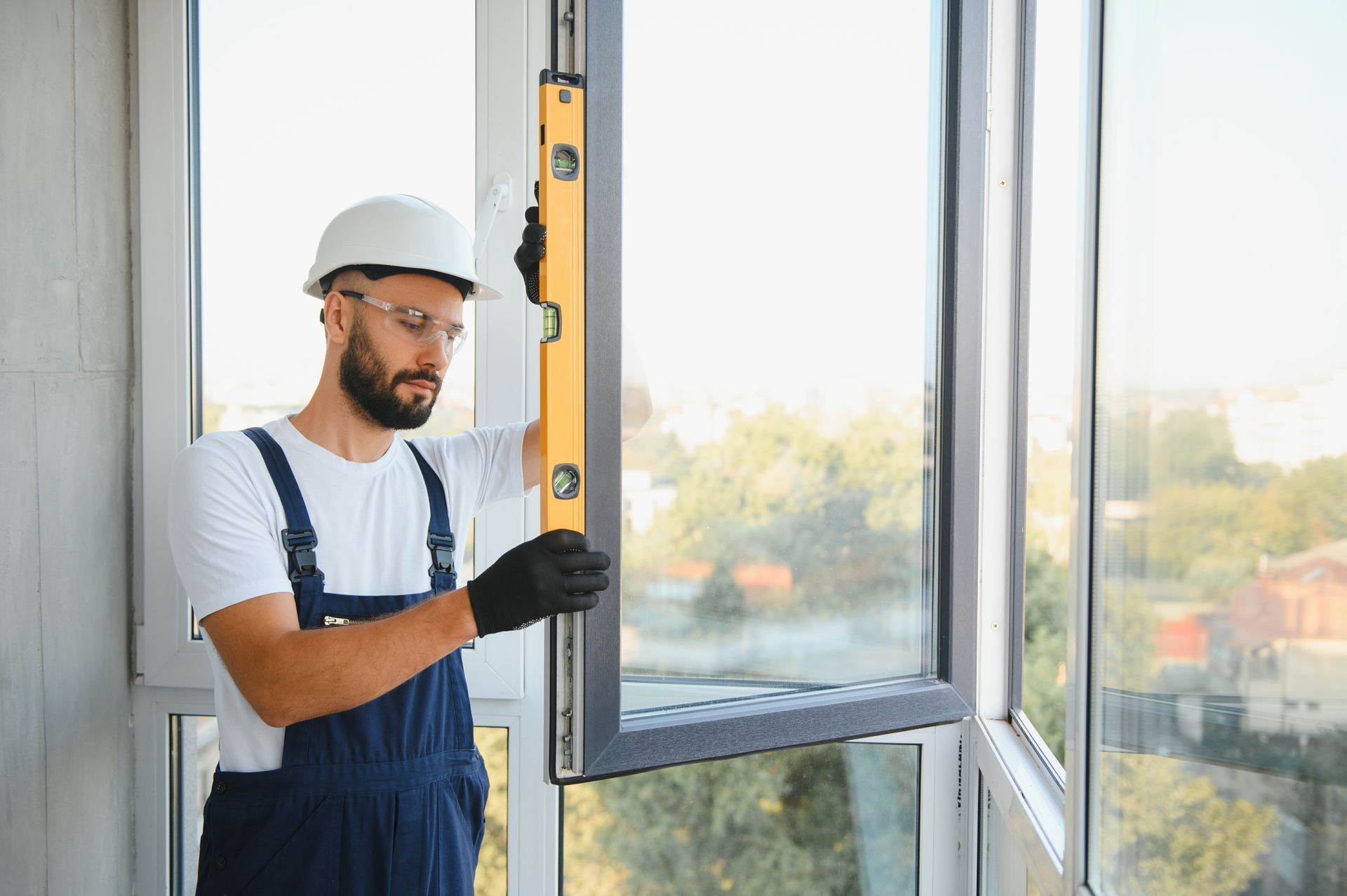 A man is measuring a window frame with a level.