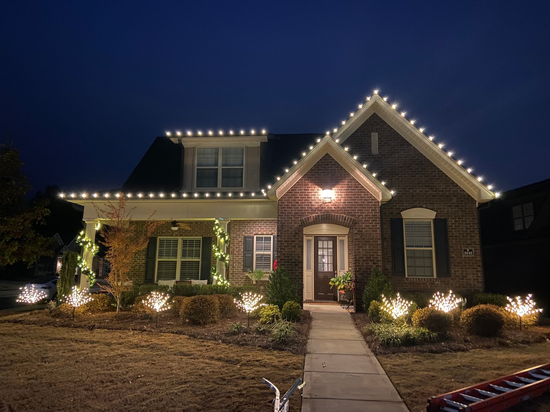 Charming home with professionally installed Christmas roofline lights and wreath