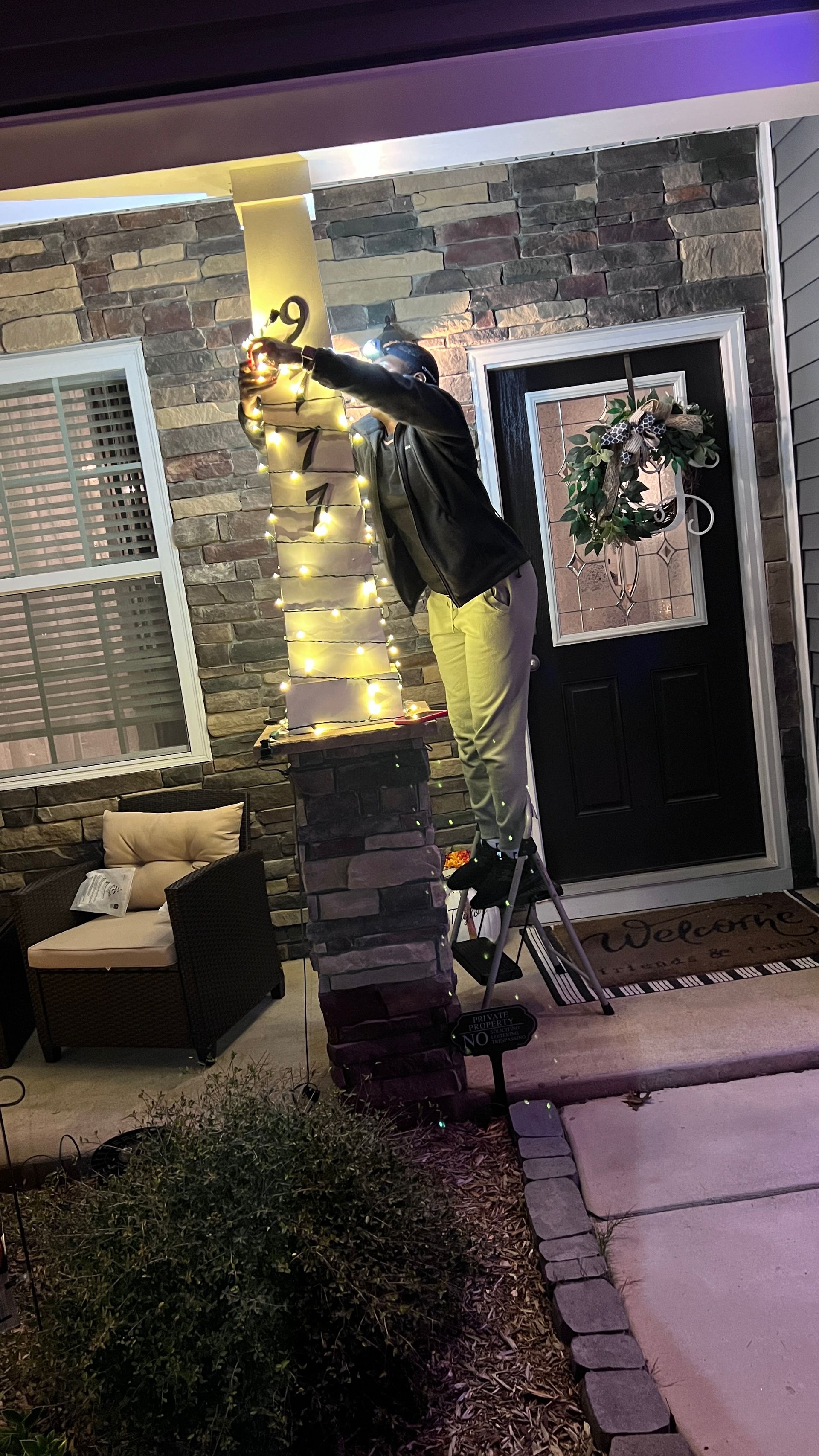 Close-up view of wreath and holiday lights on stone wall during Christmas