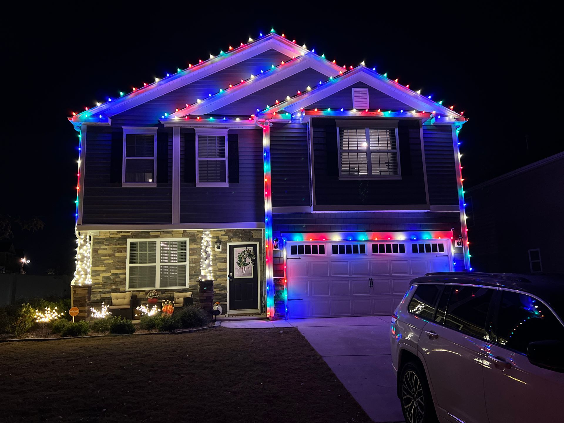 Two-story house with multicolor professional Christmas light installation