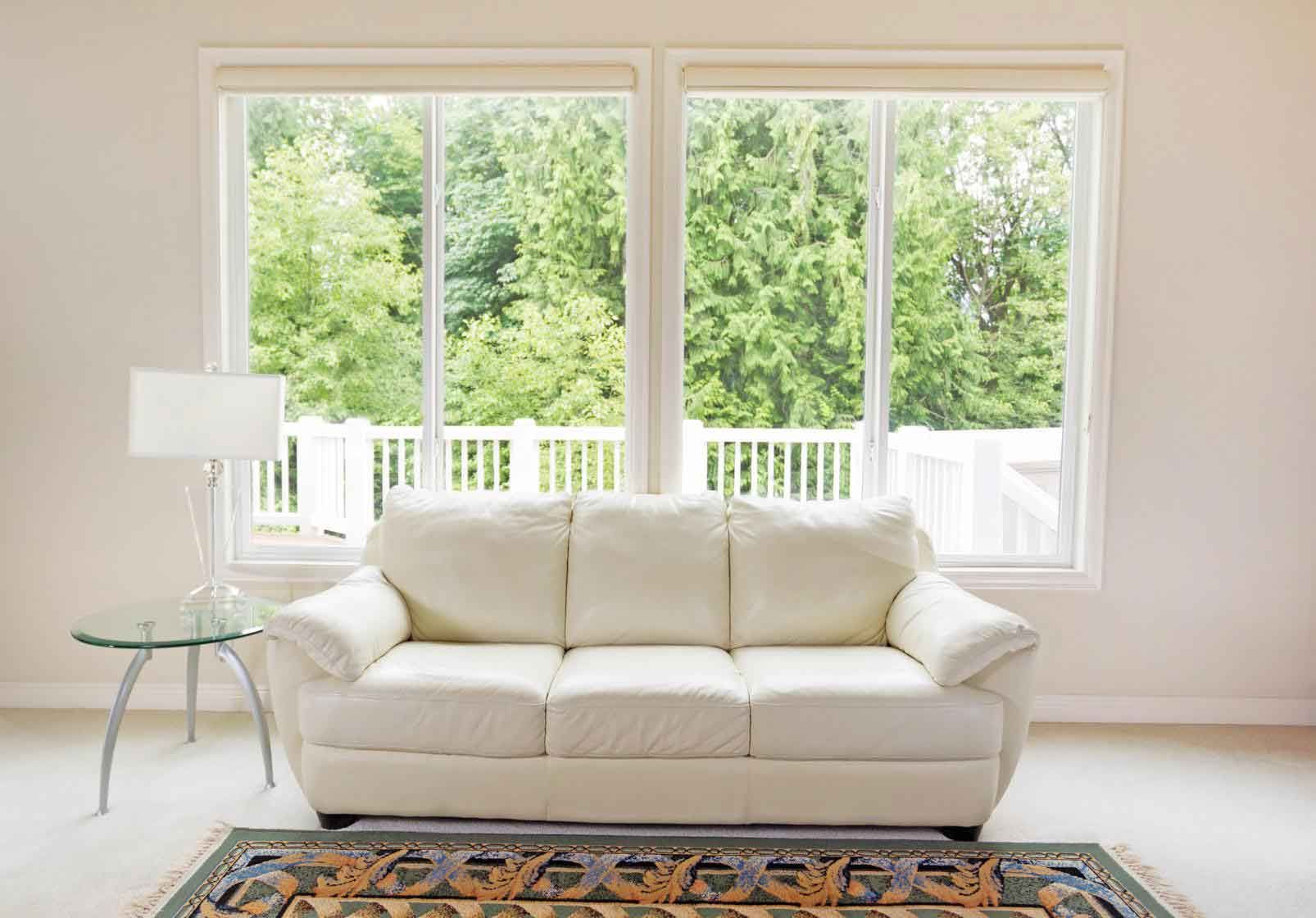 A living room with a white couch and a rug.