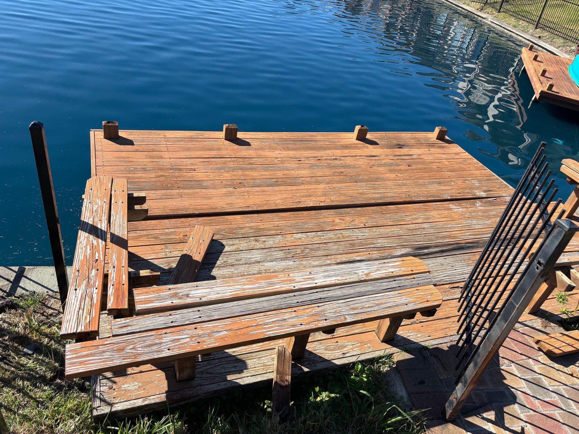Exterior wall with damaged wooden siding, showing exposed dark wood and light green paint.